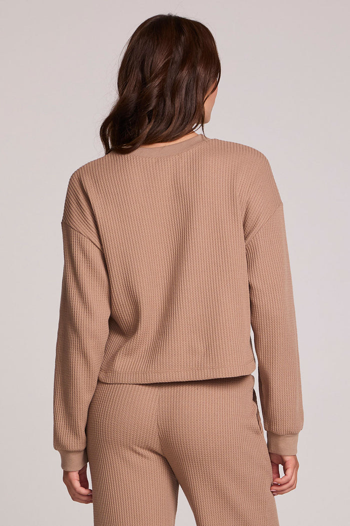 Back view of a woman wearing the Chaser Suzzans Camel Cropped Sweatshirt and pants on a neutral background