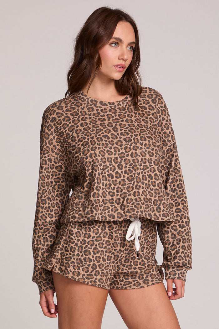 Front view of a woman wearing the Chaser Suzzans Leopard Sweatshirt on a neutral background with shorts