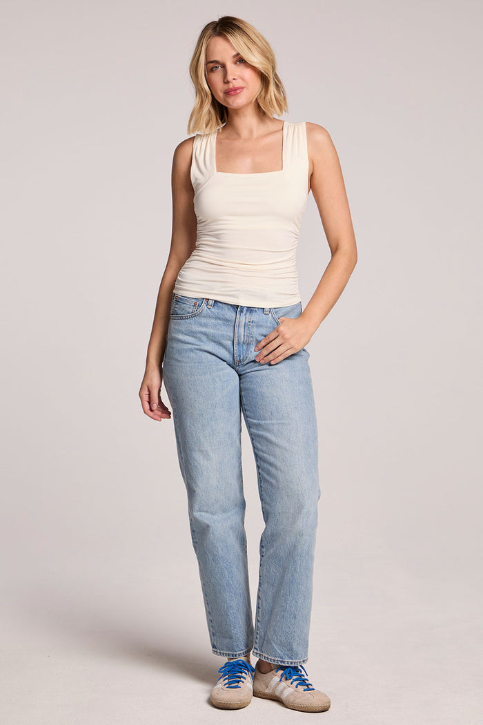Full body front of a woman wearing the Chaser Coconut Milk Sweetheart Tank Top and sneakers on a neutral background