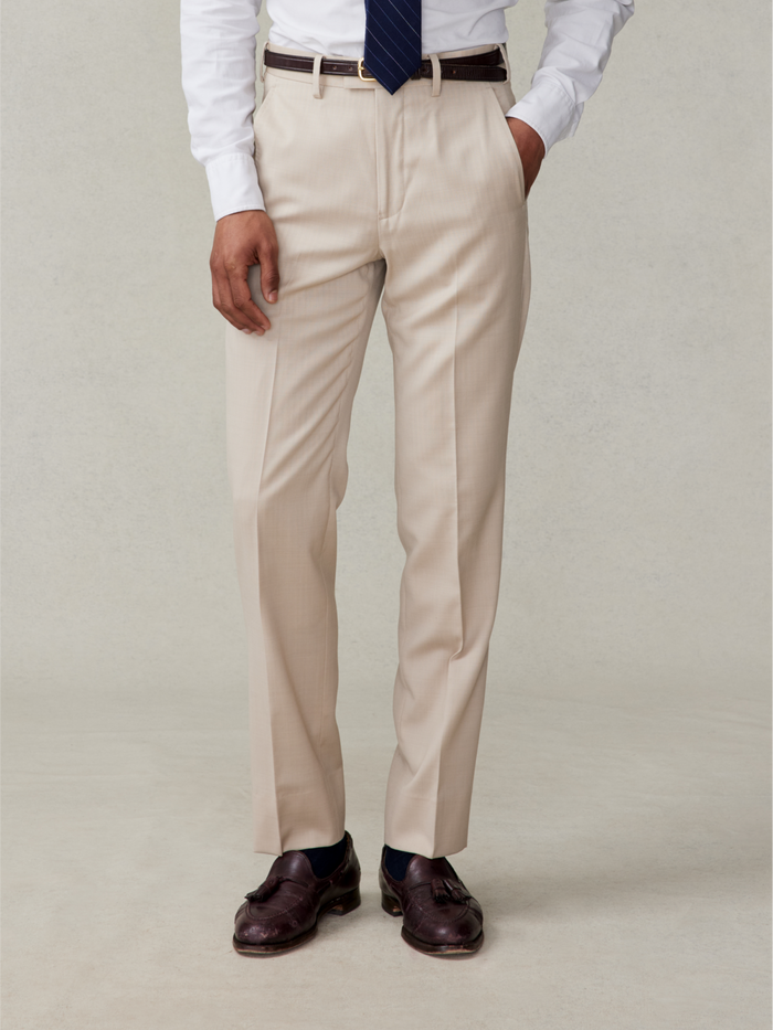 Tan suit trousers on model in white shirt and navy tie, front waist-down view