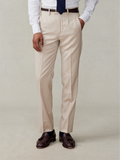 Tan suit trousers on model in white shirt and navy tie, front waist-down view
