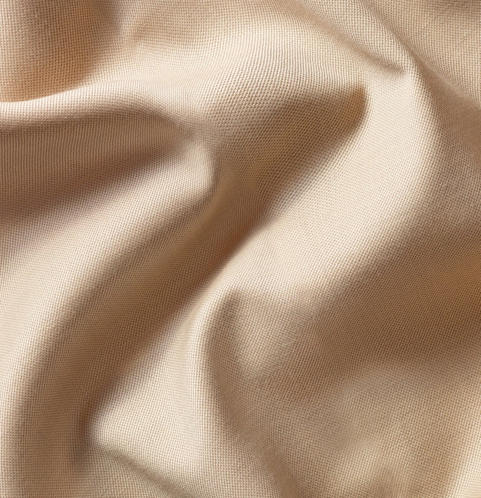 Close-up of tan suit fabric with soft draped folds