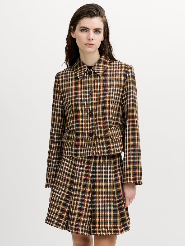 A woman wearing a heritage style checked blazer with long sleeves,button down fastening, pointed collar and a relaxed boxy fit.