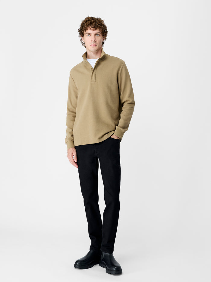 A woman wearing a taupe ottoman texture Sweatshirt with long sleeves, a funnel neckline, a branded half zip and a regular fit.