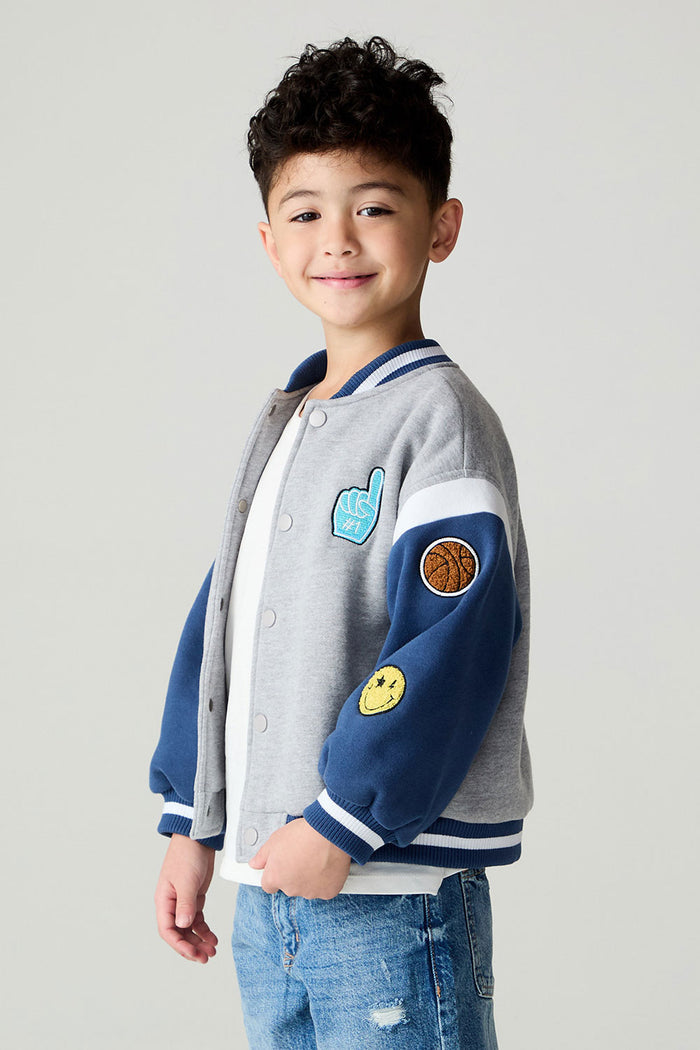 Side view of a boy wearing the Chaser Team Spirit Boys Jacket on a neutral background with jeans and shirt