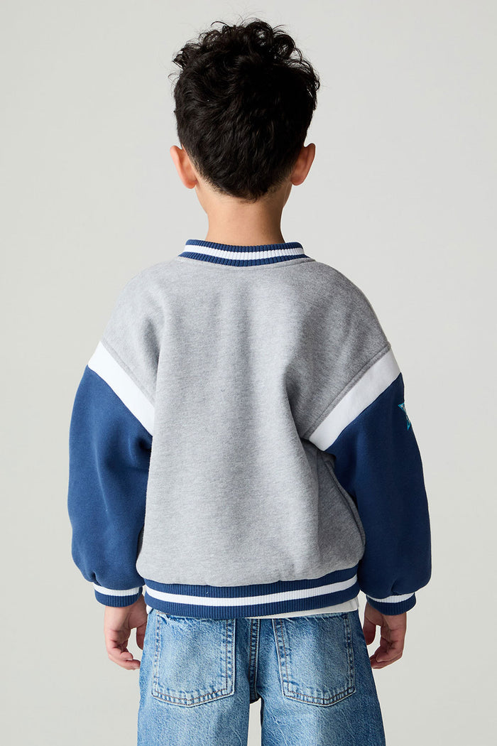 Back view of a boy wearing the Chaser Team Spirit Boys Jacket on a neutral background with jeans