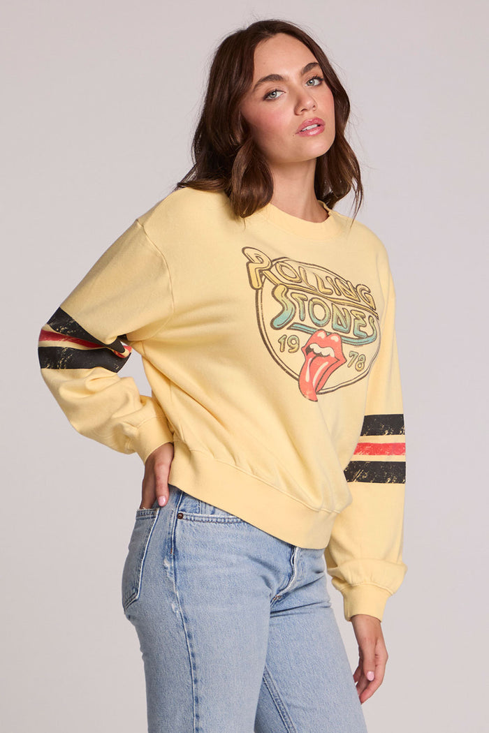 Side angle view of a woman wearing the Chaser  The Rolling Stones 1978 Long Sleeve Tee and jeans on a neutral background