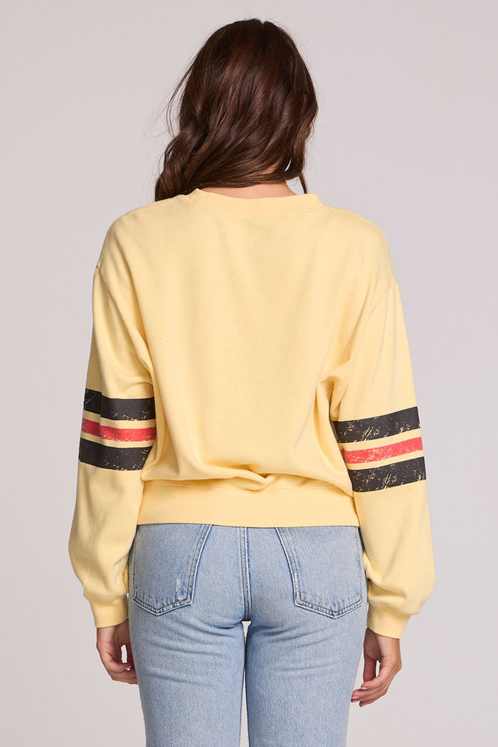 Back view of a woman wearing the Chaser  The Rolling Stones 1978 Long Sleeve Tee and blue jeans on a neutral background