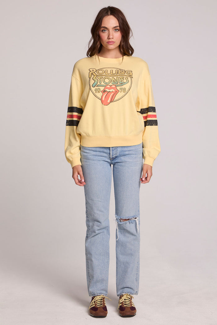 Full body front view of a woman wearing the Chaser  The Rolling Stones 1978 Long Sleeve Tee and jeans on a neutral background