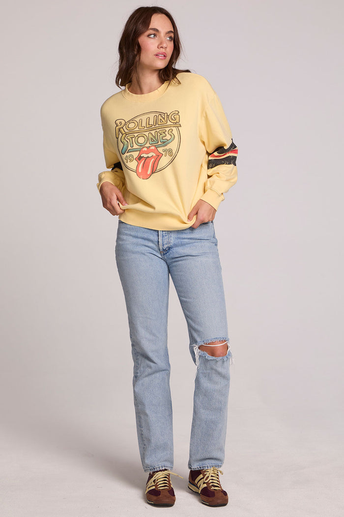 Full body front view of a woman wearing the Chaser The Rolling Stones 1978 Long Sleeve Tee and jeans on a neutral background