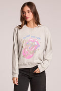 Front view of a woman wearing the Chaser  The Rolling Stones It's Only Rock & Roll Tee and jeans on a neutral background