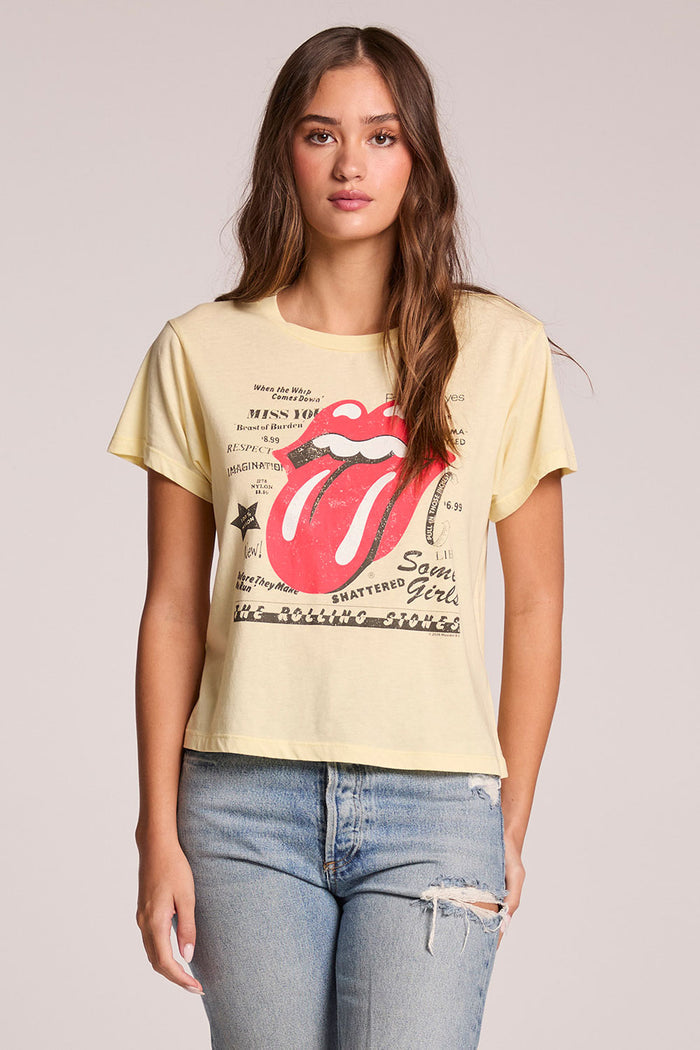 Front view of a woman wearing the Chaser  Rolling Stones Logo Magazine Mix Tee and jeans on a neutral background with hands at her side