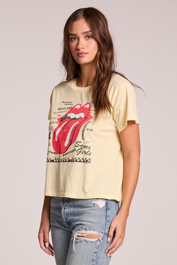 Side angle view of a woman wearing the Chaser  Rolling Stones Logo Magazine Mix Tee on a neutral background with hands at her side