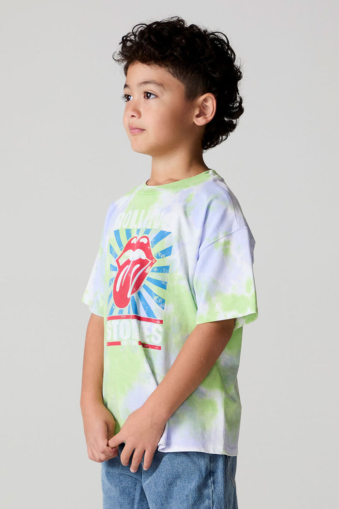 Side angle view of a boy wearing the Chaser The Rolling Stones Tie Dye Tee on a neutral background