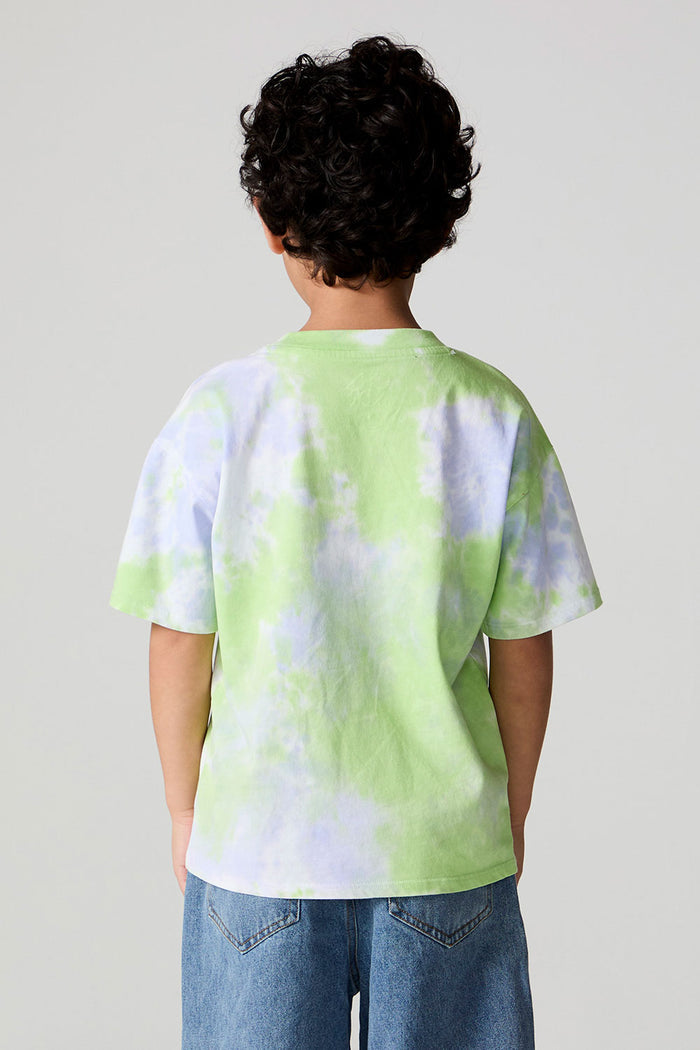 Back view of a boy wearing the Chaser The Rolling Stones Tie Dye Tee on a neutral background