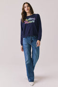 Full body view of woman wearing Chaser’s The Rolling Stones US Tour 1978 Long Sleeve in Oxford Blue with jeans on a white background