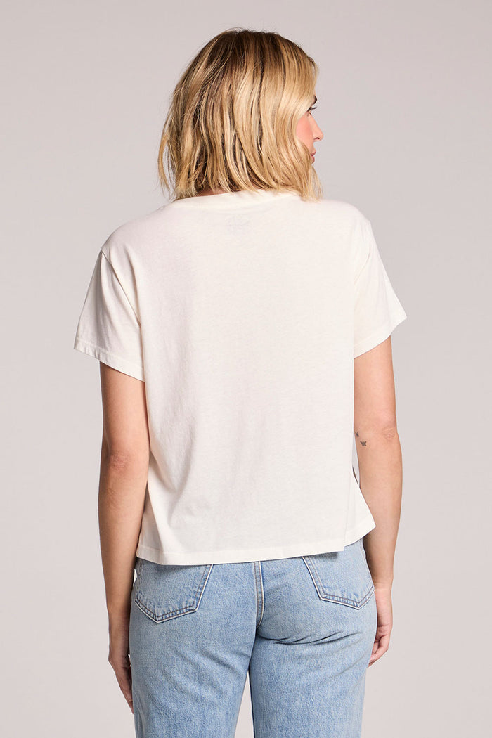 Back view of a woman wearing the Chaser The Rolling Stones USA Tour 89 Tee on a neutral background