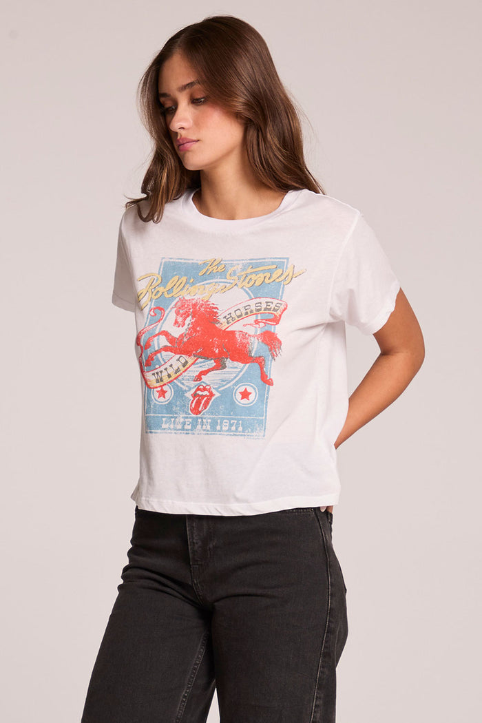 Side angle view of a woman wearing the Chaser   The Rolling Stones Wild Horses Tee on a neutral background with hands behind her back