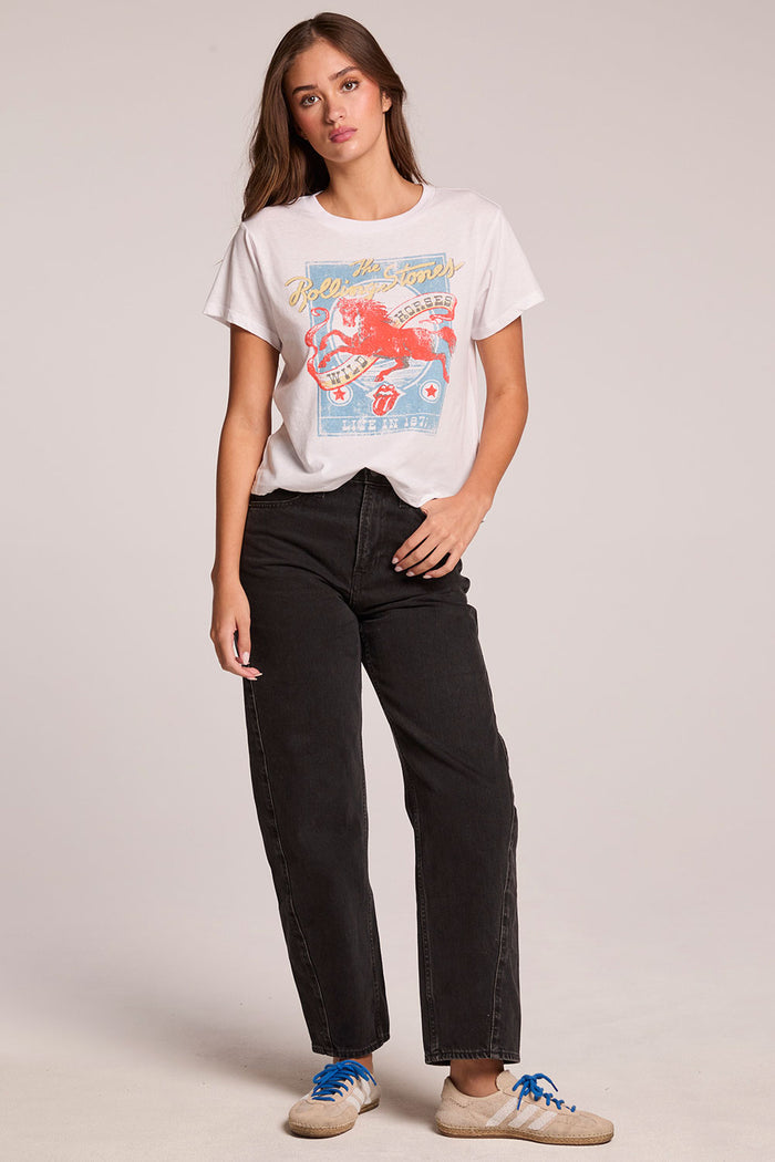 Front view of a woman wearing the Chaser   The Rolling Stones Wild Horses Tee and sneakers on a neutral background