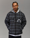 Man wearing a black and gray plaid hoodie with a brand logo on a gray background