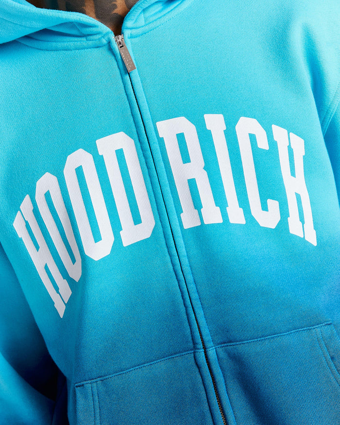 Blue hoodie with 'HOOD RICH' text on a close-up view