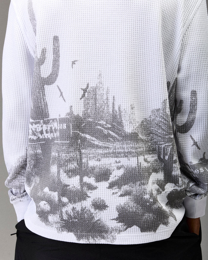 White t-shirt with black and gray graphic design of a cityscape and cacti.