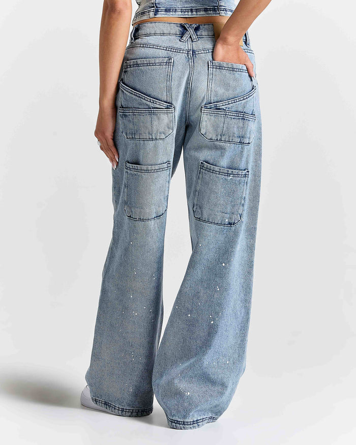 Light blue jeans with multiple pockets on a plain background