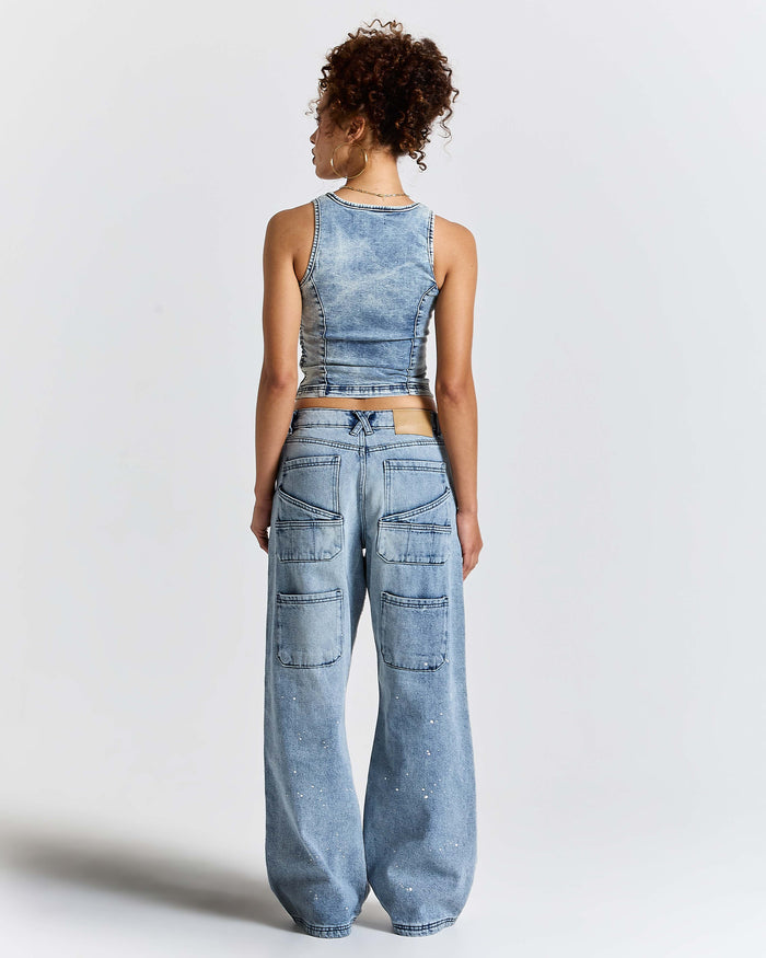 Person wearing a denim outfit with a matching top and pants on a white background