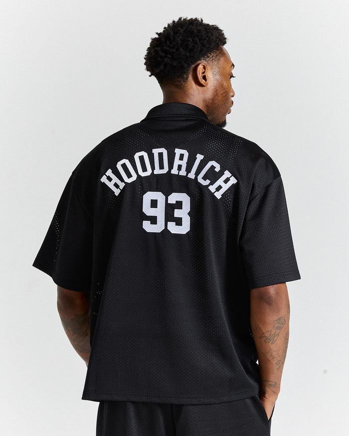 Person wearing a black 'Hoodrich 93' jersey on a white background