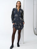 Woman wearing a long sleeve, navy mini shirt dress