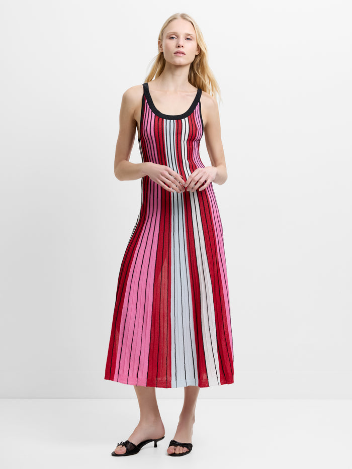 Woman wearing a pink, red and white striped, textured knitted midi dress with straps and a scoop neckline