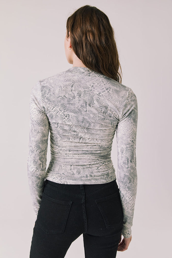 Back view of woman wearing Chaser’s Tilly Python Print Long Sleeve on a plain background