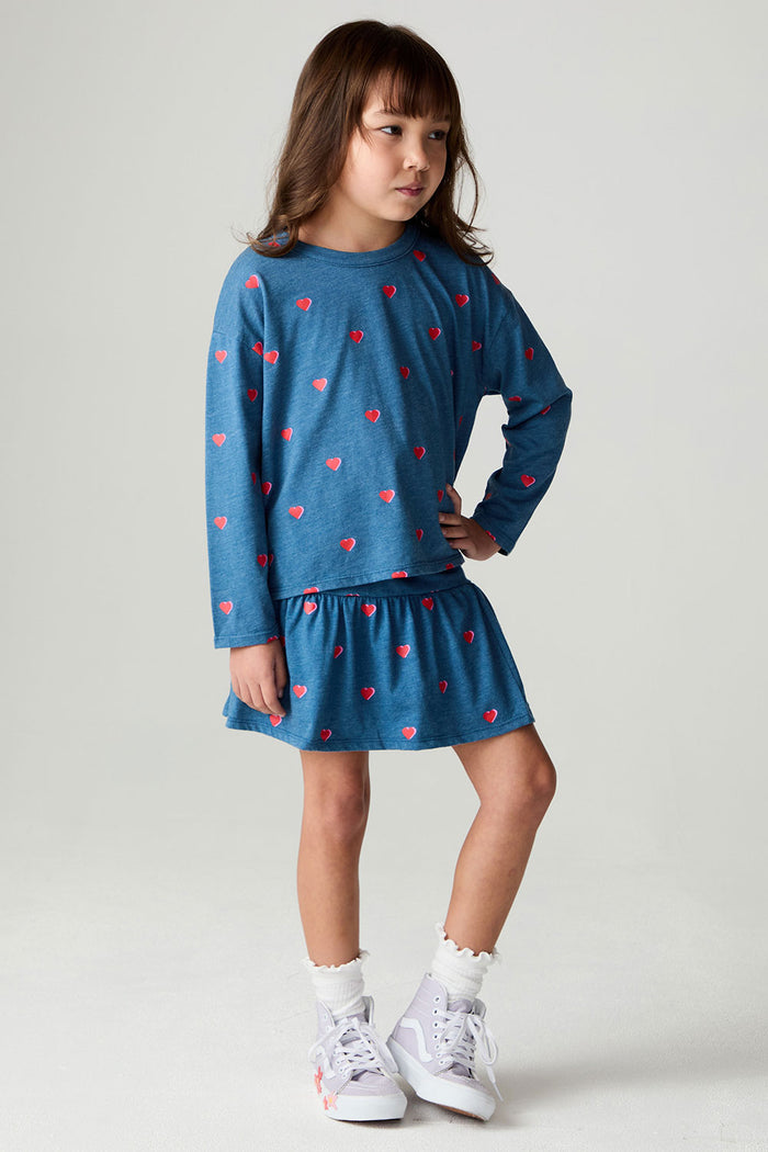 A full body front view of a girl wearing the Chaser Tiny Hearts Girls Tee on a neutral background