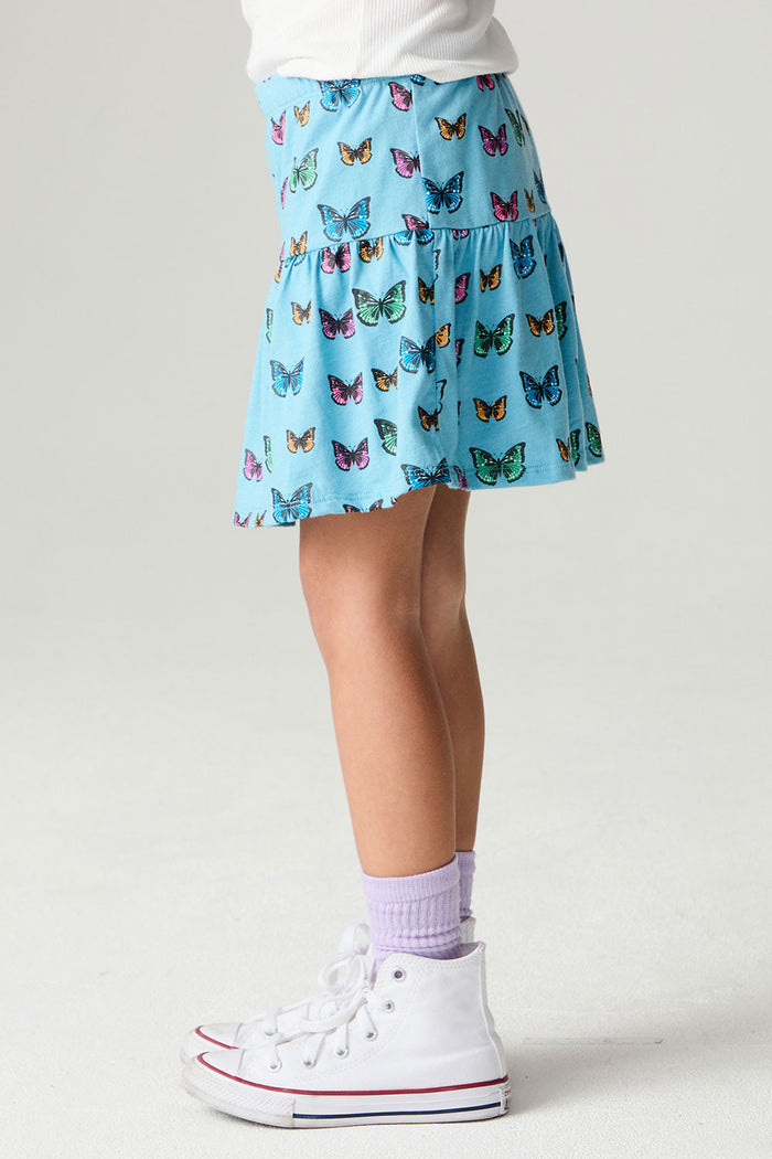 Side view of a girl wearing the Chaser Flutter Pop Girls Skirt on a neutral background with sneakers