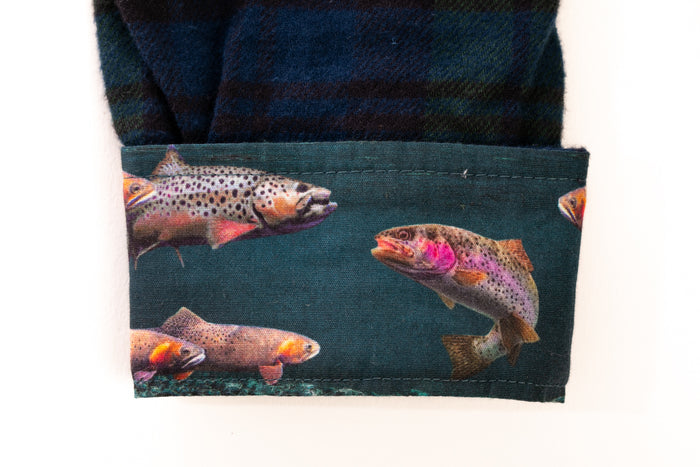 Cuff of Pladra's Toddler Cubs Flannel Shirt in Bolinas Blue with plaid and colorful trout swimming underwater.