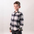 A young boy in the Pladra Toddler Cubs Flannel Shirt - Sterling Grey Heather poses confidently against a light background.