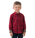 Smiling boy in a Pladra Toddler Cubs Flannel Shirt–Wrangler Red and dark jeans, standing against a white background.