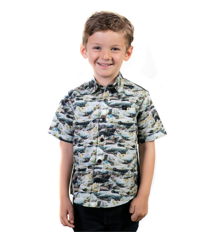 Toddler Cubs Outdoor Aloha Shirt in Seals, a cotton short-sleeve shirt with a seal pattern, worn by a young boy.