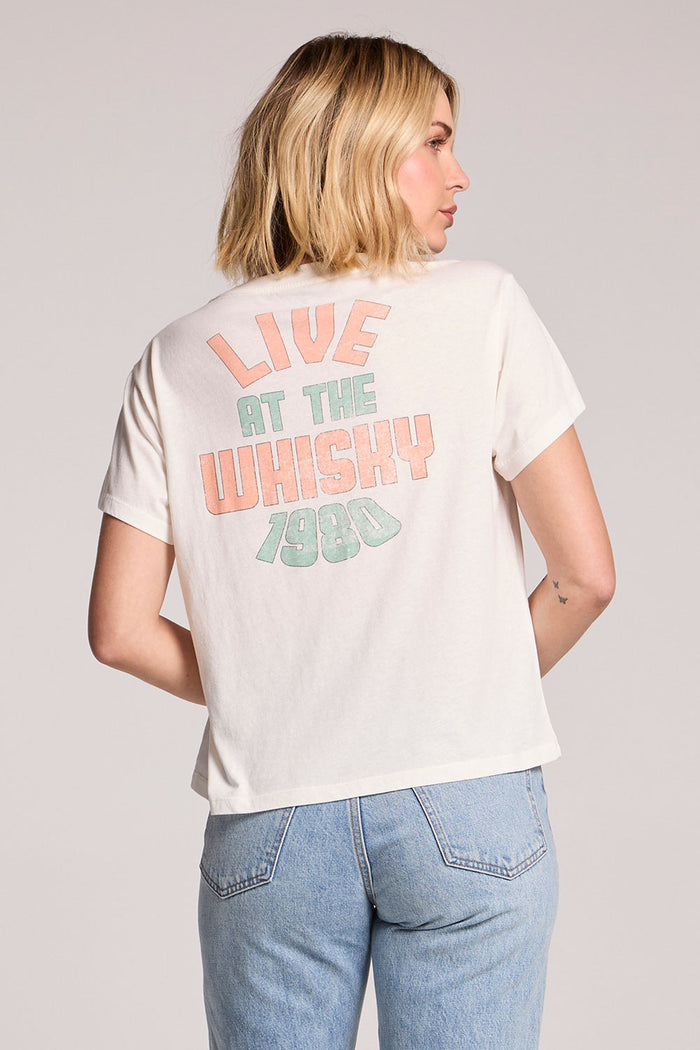 Back view of a woman wearing the Chaser Tom Petty Live at the Whiskey 77 Tee on a neutral background
