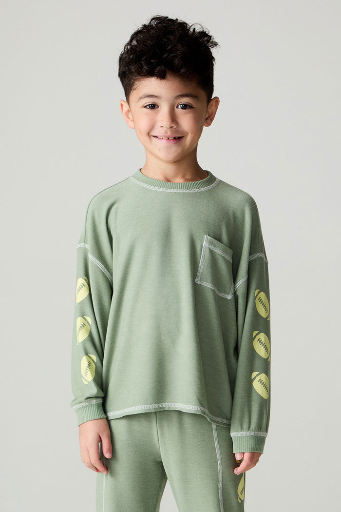 Front view of a boy wearing the Chaser Touchdown Boys Tee on a neutral background with matching long-sleeve shirt