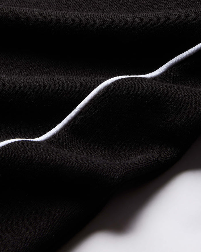 Black fabric with a white line running through it on a dark background