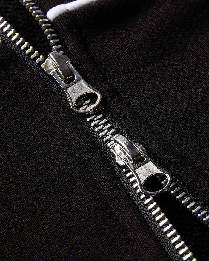 Close-up of a silver zipper on a black background