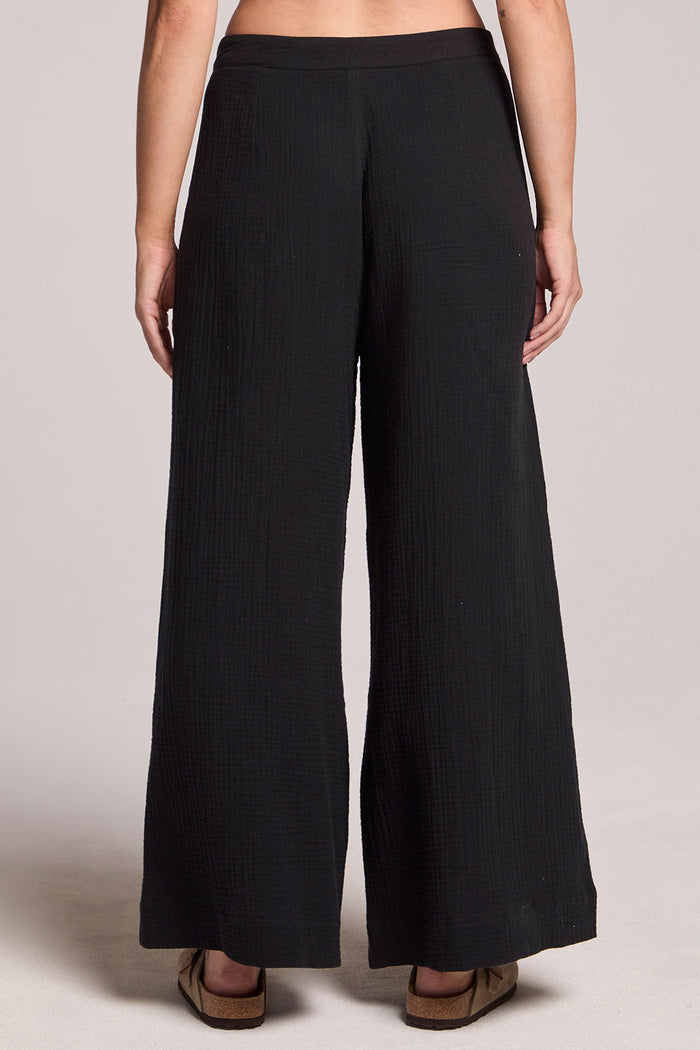 Back view of a woman wearing the Chaser True Black Campaniaa Trousers on a neutral background