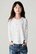 Front view of a girl wearing the Chaser Unicorn Friends Girls Tee on a neutral background with bluejeans and hands in pockets