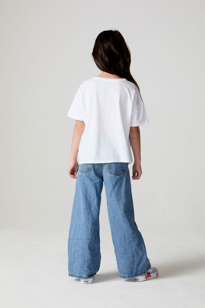 Full body back view of a girl wearing the Chaser Unicorn Parade Tee on a neutral background