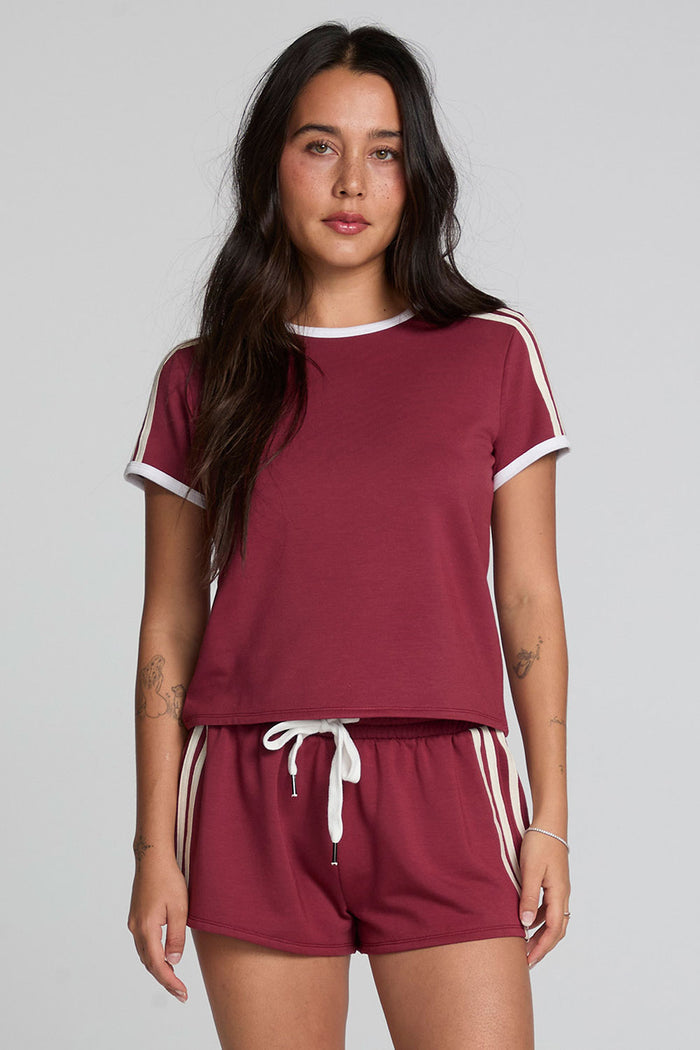 Front view of a woman wearing the Chaser Urban Burnt Red Tee on a neutral background with matching shorts