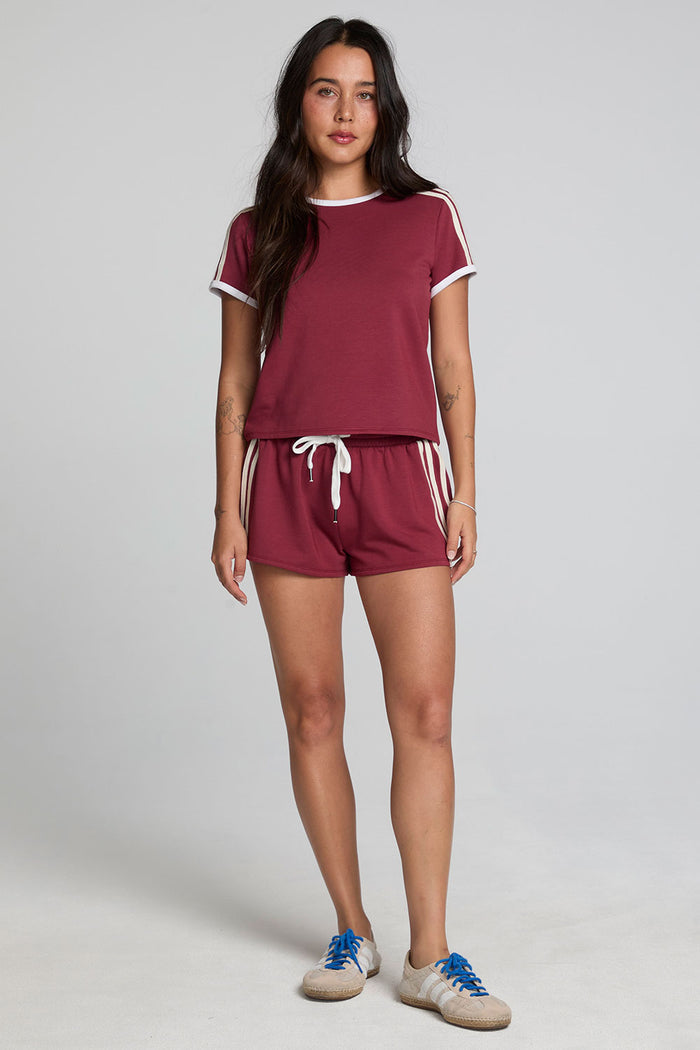 A full body front view of a woman wearing the Chaser Urban Burnt Red Tee on a neutral background