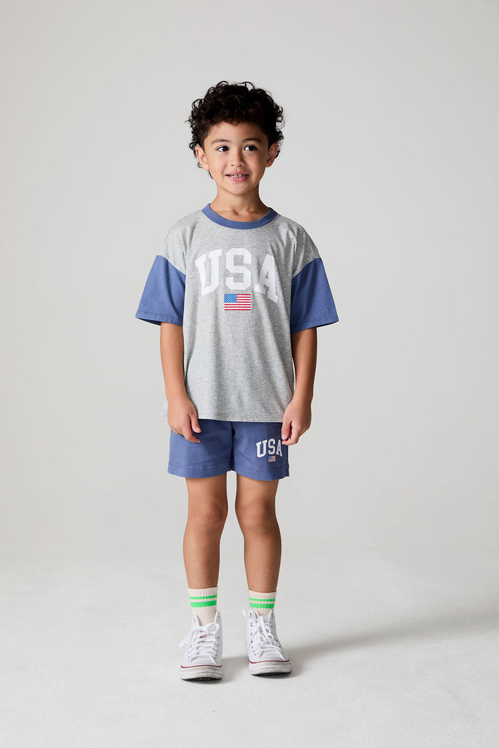Full body front view of a boy wearing the Chaser U.S.A. Flag Tee on a neutral background