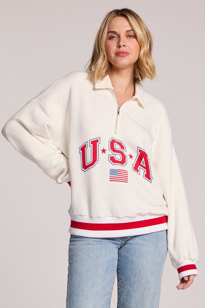 Front view of a woman wearing the Chaser USA Pullover with one hand on her hip on a neutral background
