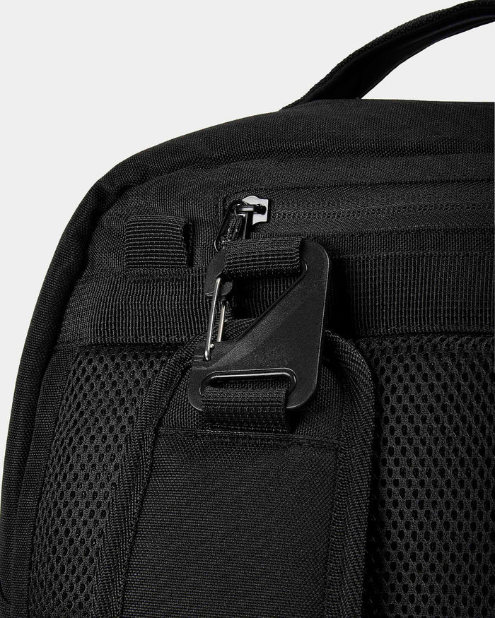 Close-up of a black backpack with zippers on a light gray background